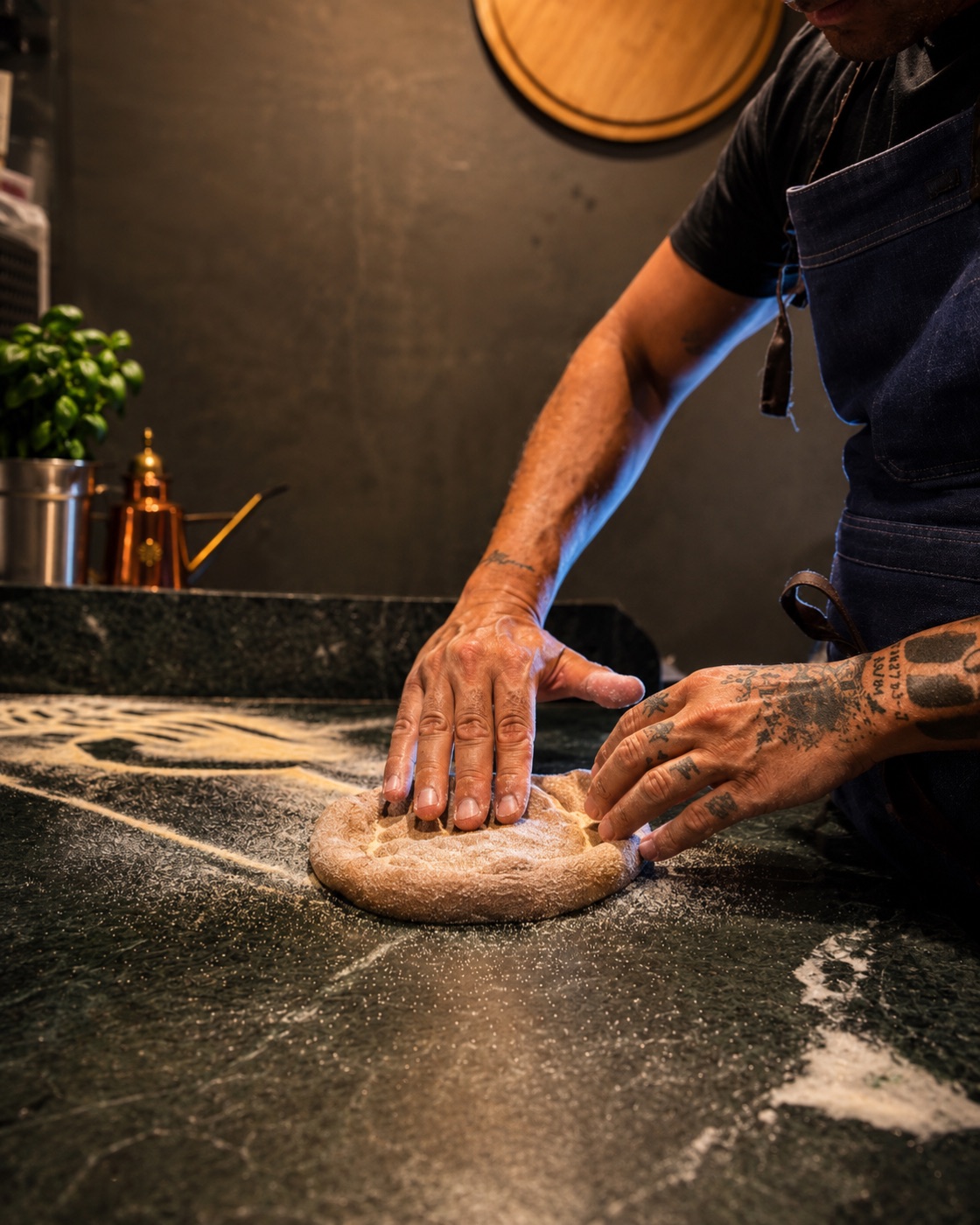 Pizzaiolo estirando a mano la masa artesanal
